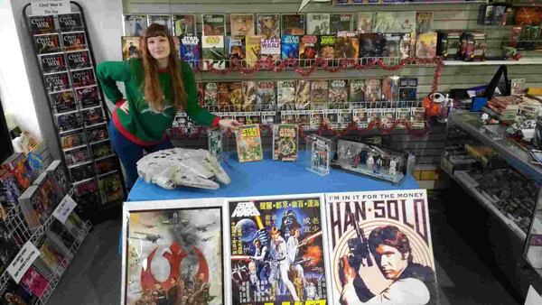 Andrea Puttkammer, daughter of Galactic Quest comic book store co-owners Kyle and Cynthia Puttkammer, poses among some of the “Star Wars” memorabilia that will be displayed at the Buford store’s “Star Wars” Extravaganza event on Dec. 17. CONTRIBUTED BY GALACTIC QUEST