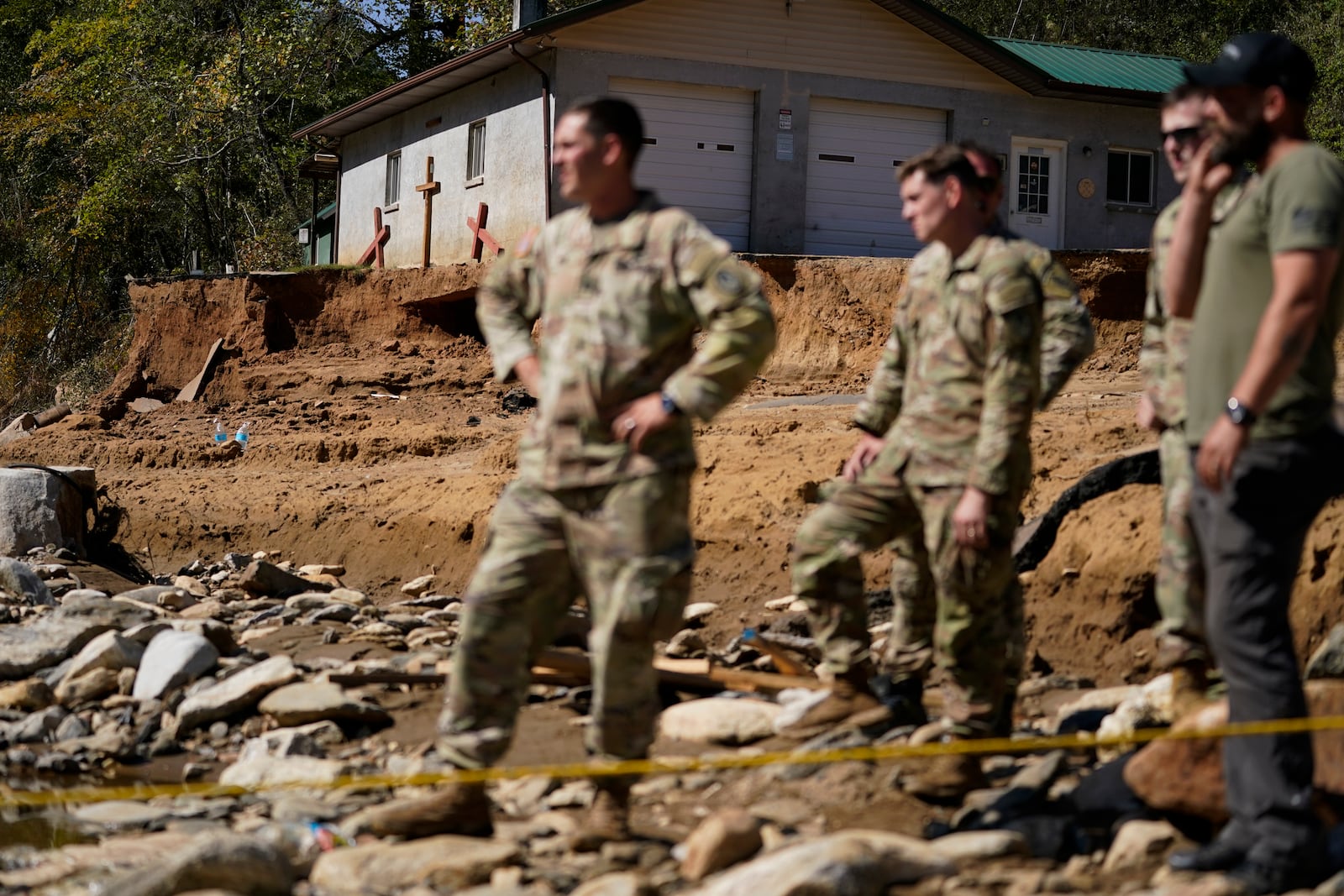 Members of the National Guard stand of a debris field in the aftermath of Hurricane Helene on Tuesday, Oct. 8, 2024, in Burnsville, N.C. (AP Photo/Erik Verduzco)