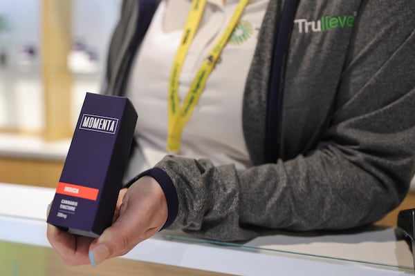 Holly Chapman, general manager at Trulieve Medical Marijuana Dispensary in Marietta holds a box that contains Indicus cannabis tincture. Trulieve has opened dispensaries in Marietta and Macon and is expected to open three more in Georgia this summer. (Natrice Miller/natrice.miller@ajc.com)