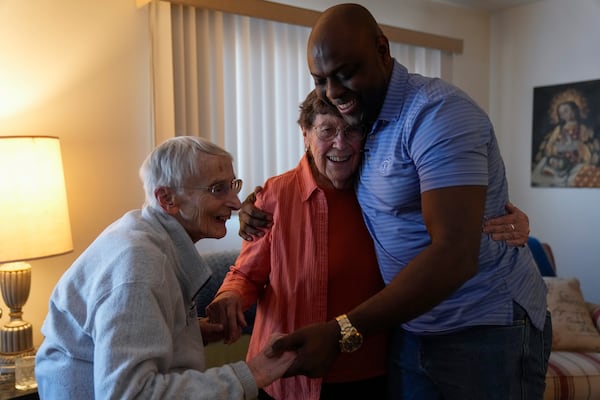 Oscar, an immigrant from Central America seeking asylum, right, visits Sister Pat Murphy, 95, left, and Sister JoAnn Persch, 90, nuns with the Sisters of Mercy, at their home Thursday, Feb. 20, 2025, in Alsip, Ill. (AP Photo/Erin Hooley)