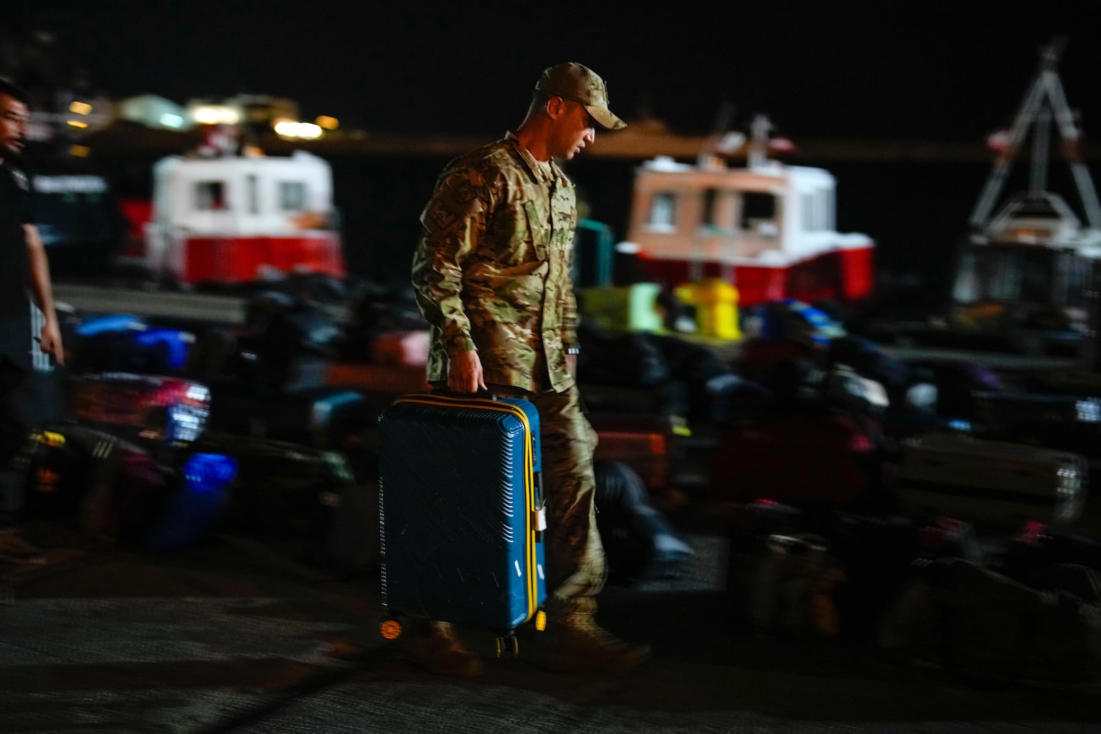 A Turkish military officer inspects the luggage of Turkish citizens to be evacuated on Turkish military ships from Lebanon to Turkey, in Beirut port, Wednesday, Oct. 9, 2024. (AP Photo/Emrah Gurel)