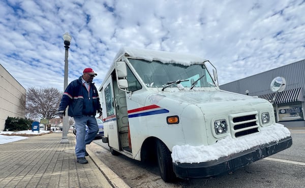 Mail carrier Al Mitchell climbs into his snow-coated truck parked outside City Hall in downtown Cordele on Thursday, Jan. 23, 2025. (Joe Kovac Jr./AJC)