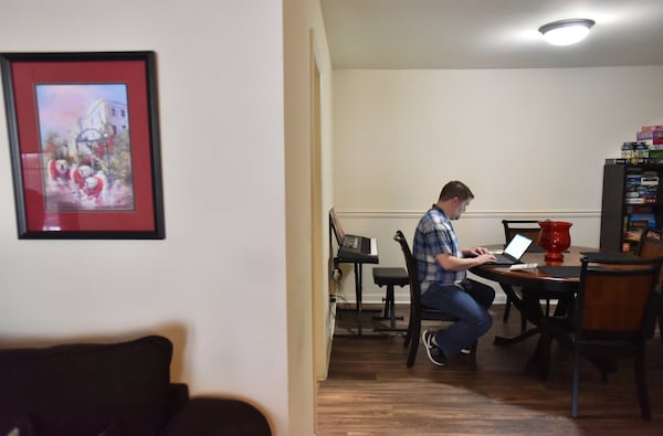 Patrick Hill works on his laptop at his apartment home in Sandy Springs. The CPA is now a full-time employee at Home Depot, but he worked contract jobs for a decade. HYOSUB SHIN / HSHIN@AJC.COM