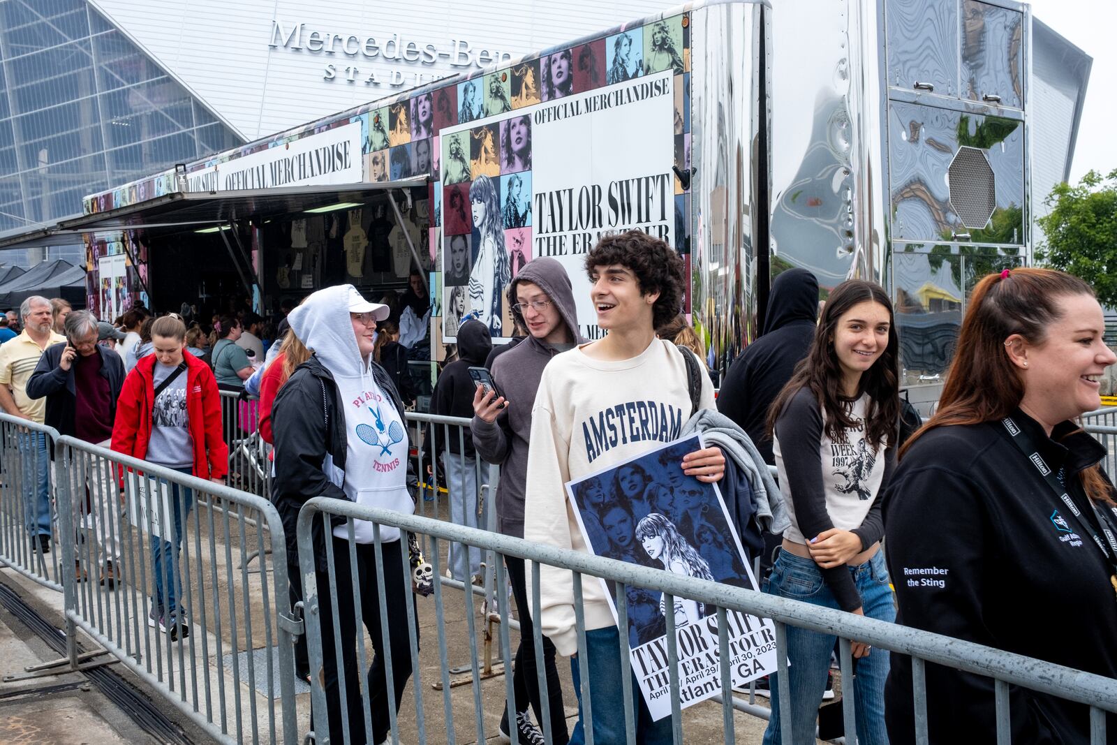 Luke McCullough of Atlanta holds a poster while waiting in line for Taylor Swift merchandise in front of Mercedes-Benz stadium in Atlanta on Thursday, April 27, 2023. (Arvin Temkar / arvin.temkar@ajc.com)