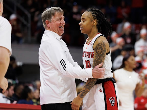 North Carolina State head coach Wes Moore, left, smiles with NC State's Aziaha James (10) in the final moments of his team's victory over Notre Dame in an NCAA college basketball game in Raleigh, N.C., Sunday, Feb. 23, 2025. (AP Photo/Ben McKeown)