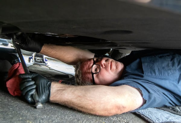 Kevin Keller gives a car an oil change in a parking lot in Roswell on Monday, July 12, 2021. Keller runs his own mobile car repair business and will meet customers where they want their services done. (Christine Tannous / christine.tannous@ajc.com)