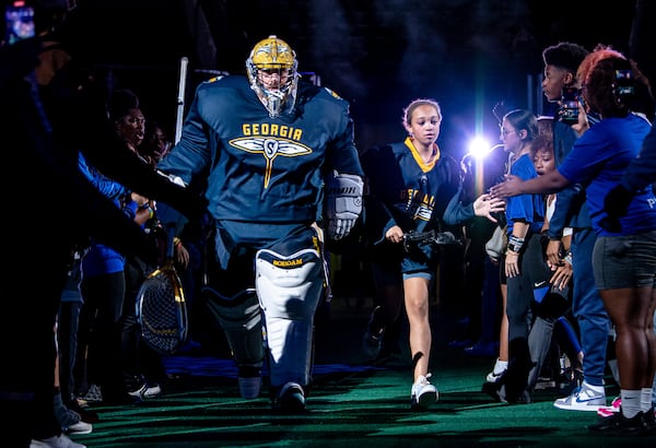 Karaline Apoian runs through the tunnel with Georgia Swarm goalie Craig Wende. Courtesy of Georgia Swarm.