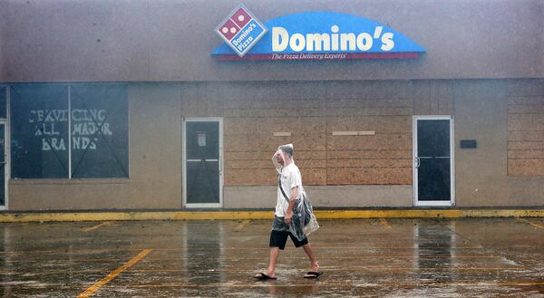 Michael Whitmore, a St. Marys resident, passes by a boarded up pizza business searching for an open store for supplies on Hwy 40 West as Hurricane Matthew hits the area on Friday, Oct. 7, 2016, in Saint Marys.