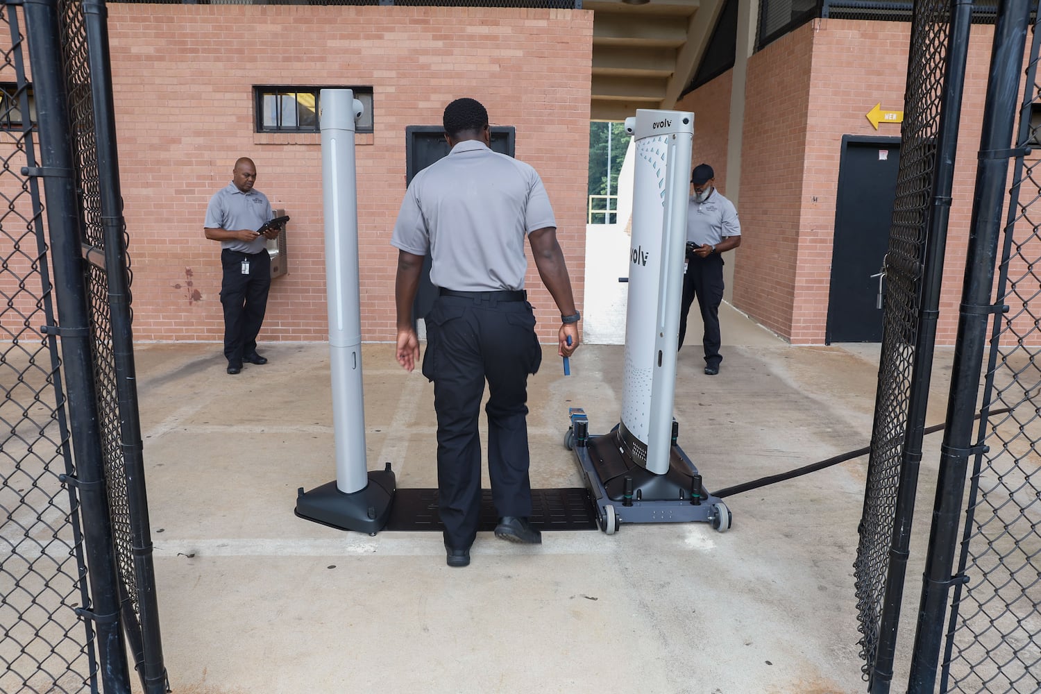 Antonio Johnson, an analyst with the DeKalb County Safe Schools program, walks through the Evolv weapons detection system during a test run at Adams Stadium on Thursday, Aug. 15, 2024. The system has already been implemented in many DeKalb schools and will be expanding to football stadiums. (Natrice Miller/ AJC)