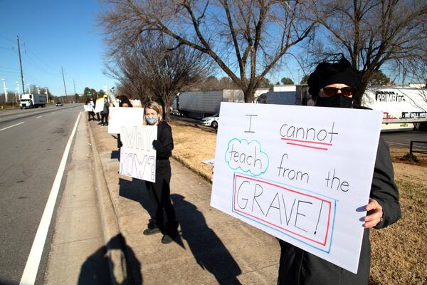 DeKalb school district teacher Laurie Law holds up a sign during a protest in front of the DeKalb school district offices along Mountain Industrial Blvd in Stone MountainTusday December 29, 2020. King says she has two children that teach in the DeKalb school district. STEVE SCHAEFER FOR THE ATLANTA JOURNAL-CONSTITUTION