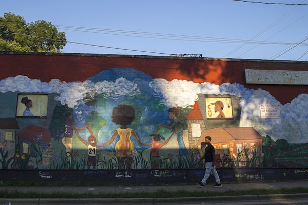 A man walks past a mural on St. Jose Street SW. Atlanta’s Ashview Heights neighborhood is next door to the historically black colleges of Atlanta University Center. Residents moved to the historically black area because they have personal ties to it, or see its potential. ALYSSA POINTER / ALYSSA.POINTER@AJC.COM