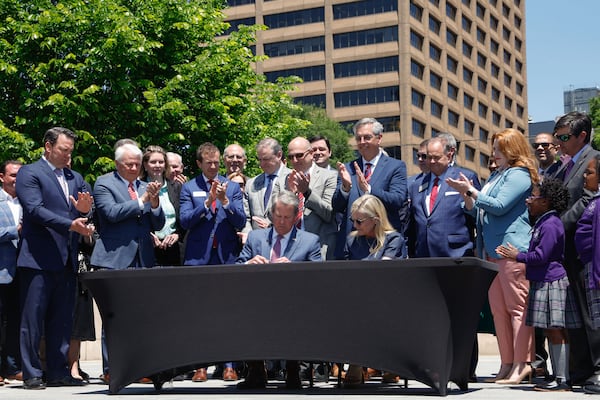 Gov. Brian Kemp signs Senate Bill 233 at Liberty Plaza on Tuesday.