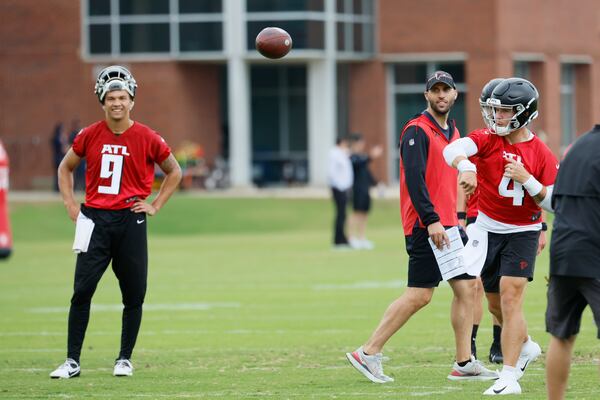 Falcons quarterback Taylor Heinicke (4) throws the ball as Falcons offensive coordinator and quarterback Desmond Ridder (9) looks during a minicamp at the Atlanta Falcons Training Camp on Wednesday, June 14, 2023, in Flowery Branch, Ga.
 Miguel Martinez / miguel.martinezjimenez@ajc.com