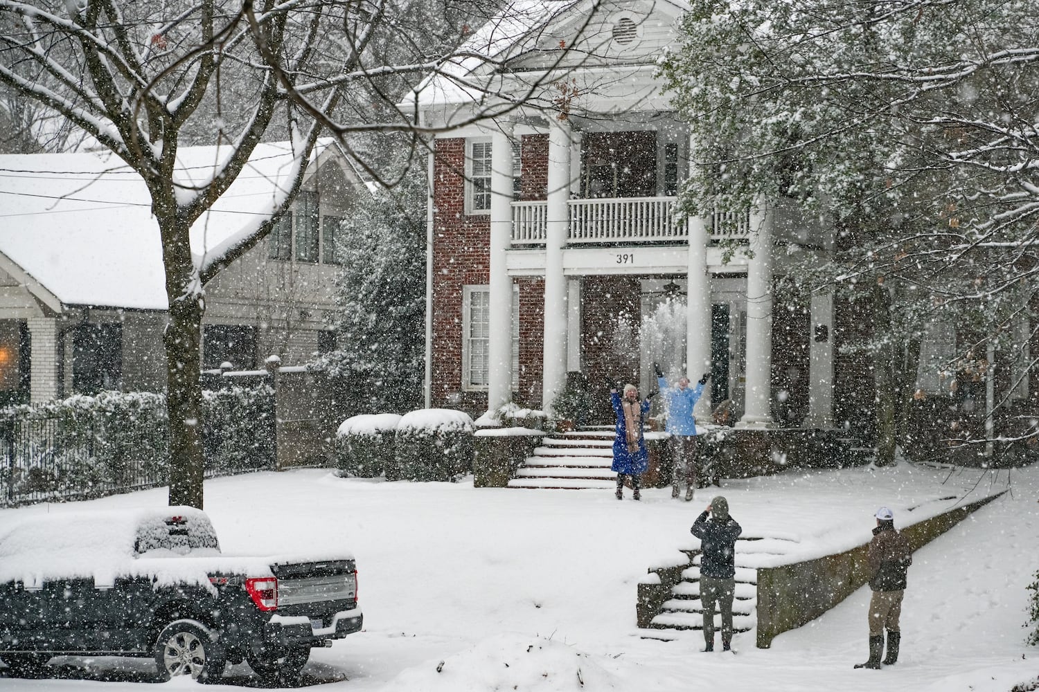 A family takes photos in the snow in Piedmont Park. Friday,  January 10, 2025 (Ben Hendren for the Atlanta Journal-Constitution)