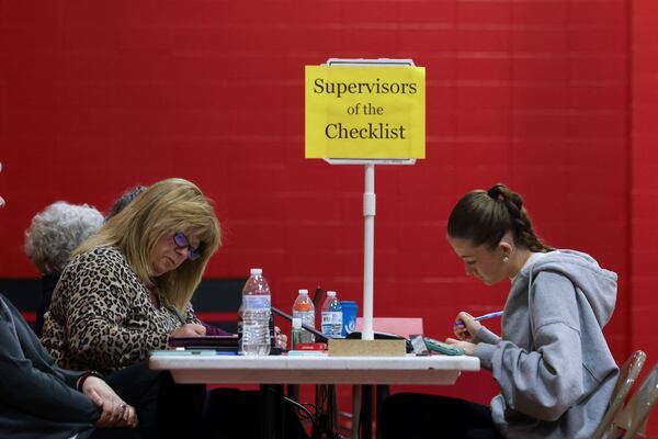 Supervisor of the Checklist for the State of New Hampshire Leslie Dombroski, left, registers Elise Collins, 18, to vote in Derry, N.H., Tuesday, March 11, 2025. (AP Photo/Reba Saldanha)