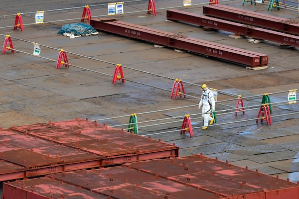 A worker in hazmat suit walks at the Fukushima Daiichi nuclear power plant, operated by Tokyo Electric Power Company Holdings (TEPCO), in Okuma town, northeastern Japan on Monday Feb. 20, 2025. (AP Photo/Eugene Hoshiko)