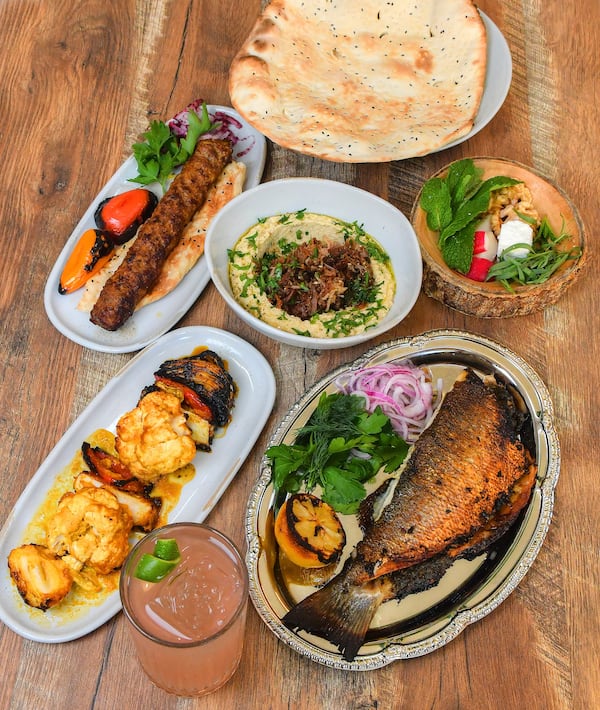 Delbar offers Persian delights, including, clockwise from top: herb cheese and bread, stuffed trout, hummus with lamb and za'taar (center), koobideh and grilled veggies. Chris Hunt for The Atlanta Journal-Constitution