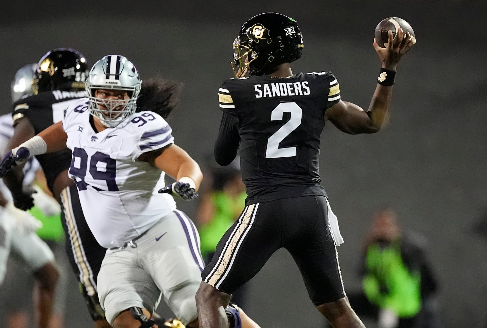 Colorado quarterback Shedeur Sanders, right, passes the ball as Kansas State defensive tackle Uso Seumalo pursues in the first half of an NCAA college football game Saturday, Oct. 12, 2024, in Boulder, Colo. (AP Photo/David Zalubowski)