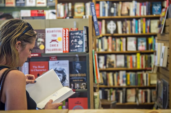 Katie Ellis thumbs through a book at A Cappella bookstore in Atlanta, a local staple for decades. CREDIT: Jonathan Phillips