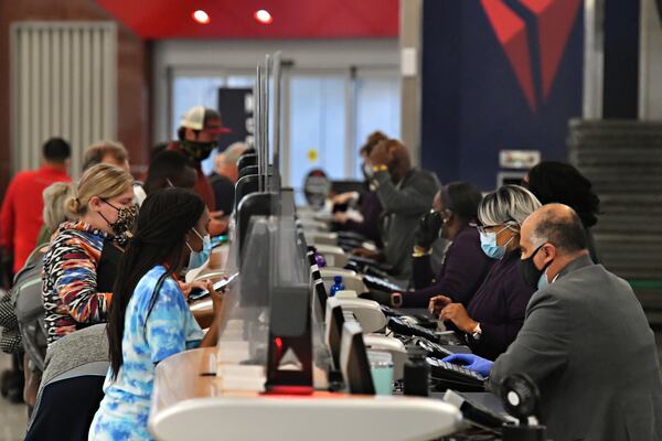  Delta Air Lines employees work the ticket counter in the Domestic Terminal at Hartsfield-Jackson Atlanta International Airport in Atlanta. (Hyosub Shin / Hyosub.Shin@ajc.com)