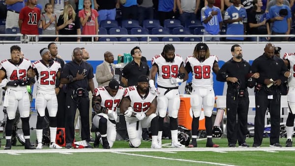 Atlanta Falcons defensive tackles Grady Jarrett (97) and Dontari Poe (92) take a knee during the national anthem before an NFL football game, Sunday, Sept. 24, 2017, in Detroit. (AP Photo/Carlos Osorio)