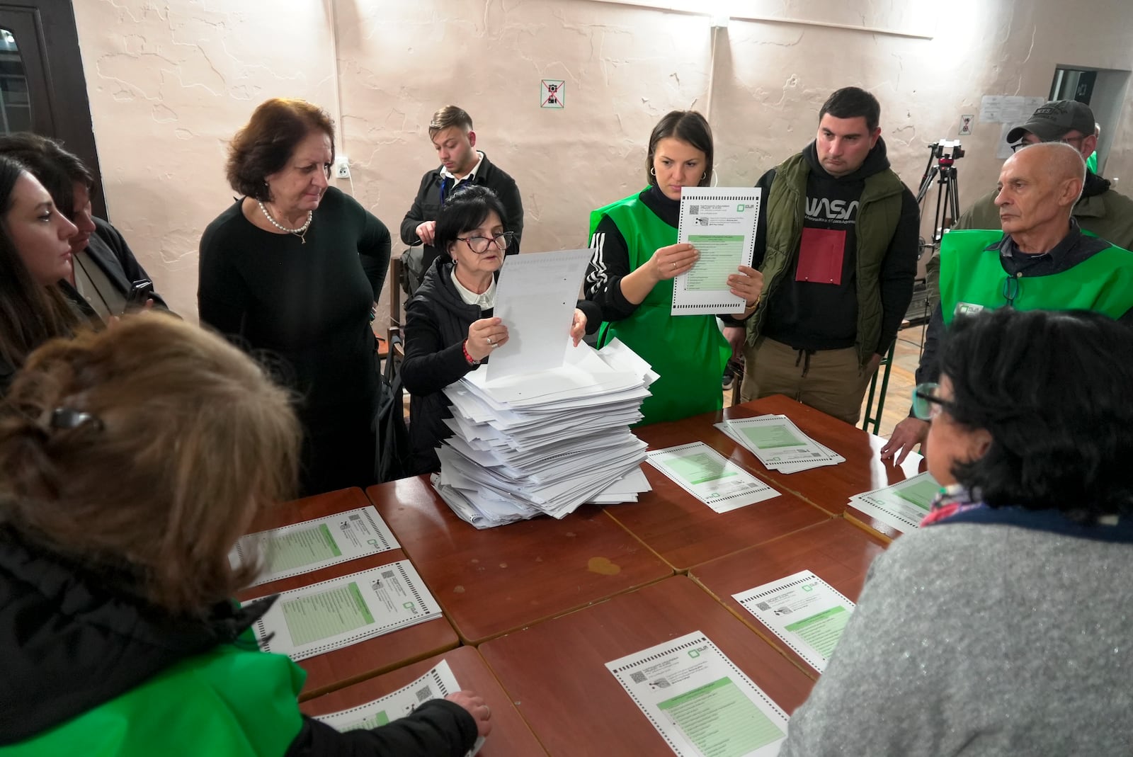 Members of an election commission count ballots at a polling station after the parliamentary election in Tbilisi, Georgia, Saturday, Oct. 26, 2024. (AP Photo/Kostya Manenkov)