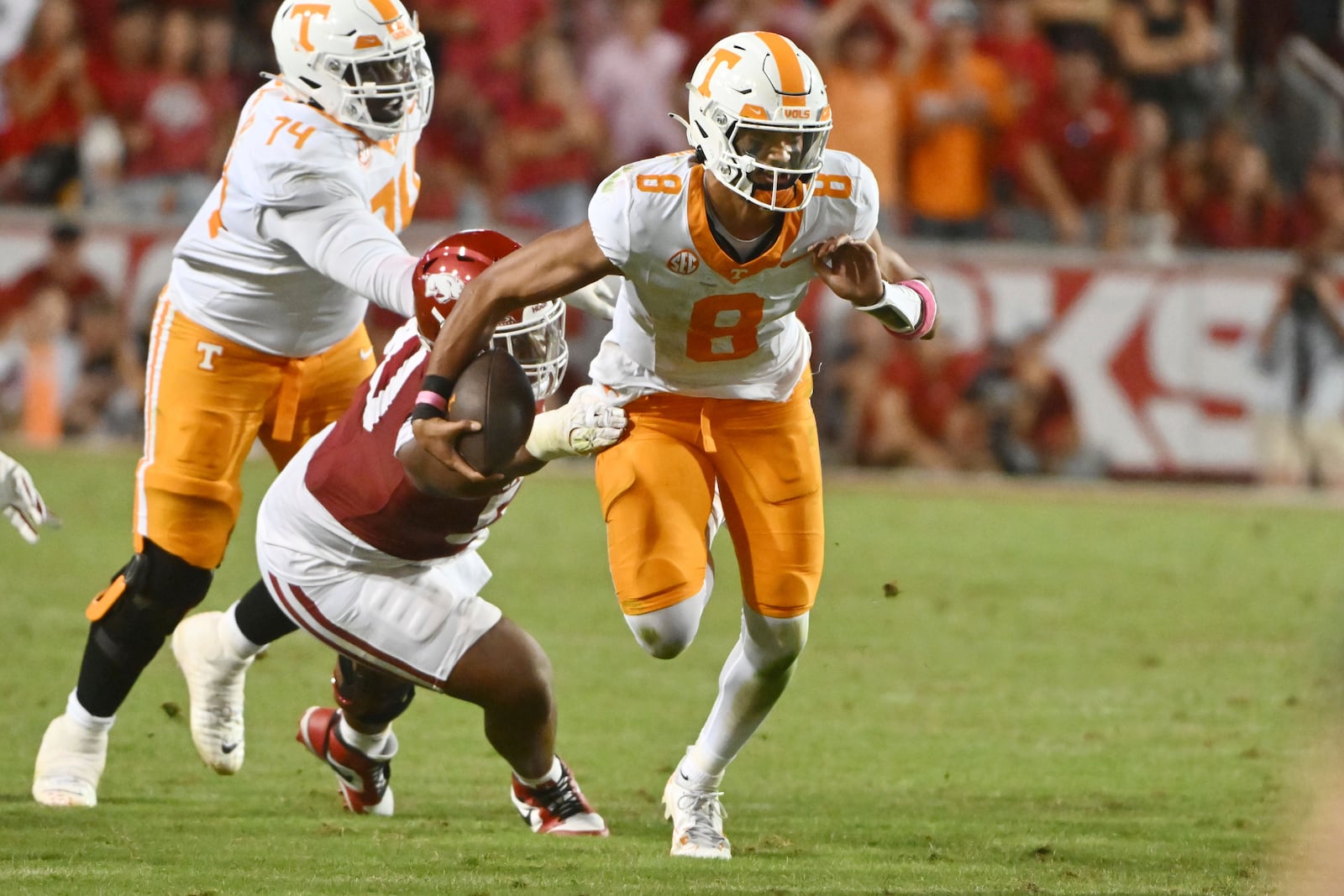 Tennessee quarterback Nico Iamaleava (8) tries to get away from Arkansas defensive lineman Eric Gregory (50) during the second half of an NCAA college football game, Saturday, Oct. 5, 2024, in Fayetteville, Ark. (AP Photo/Michael Woods)