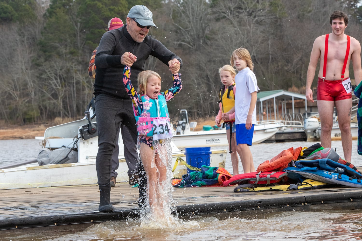 Choosing a dunk rather than a quick swim, 6-year-old Emery Ellison, visiting from Texas, participates in the 26th annual Polar Bear Paddle and Plunge at Lake Lanier Olympic Park on Monday, Jan 1, 2024.  (Jenni Girtman for The Atlanta Journal-Constitution)