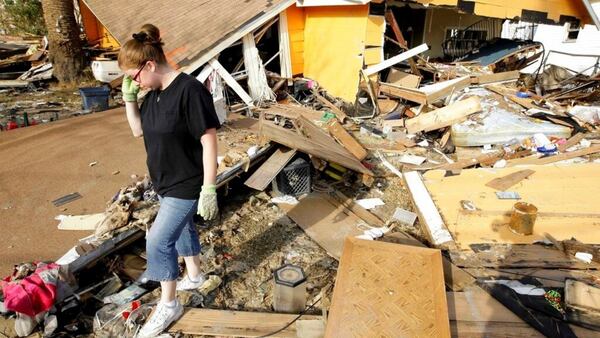 FILE - In this Sept. 24, 2008, file photo, Gina Hadley walks through what's left of her home in the aftermath of Hurricane Ike in Galveston, Texas. It s been nearly 11 years since Hurricane Ike devastated homes on the Texas island and wiped away beaches that were the lifeblood of its tourism economy. 