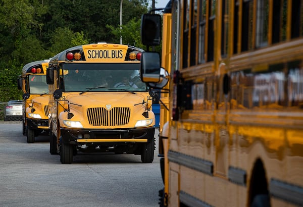 FILE - Jefferson County Public Schools buses make their way through the Detrick Bus Compound on the first day of school, Aug. 9, 2023, in Louisville, Ky. (Jeff Faughender/Courier Journal via AP, File)