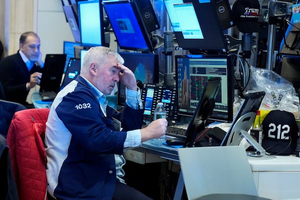 People work on the floor at the New York Stock Exchange in New York, Monday, Feb. 24, 2025. (AP Photo/Seth Wenig)