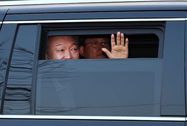 Impeached South Korean President Yoon Suk Yeol waves to his supporters upon his arrival outside of presidential residence in Seoul, South Korea, Saturday, March 8, 2025. (Kim In-chul/Yonhap via AP)