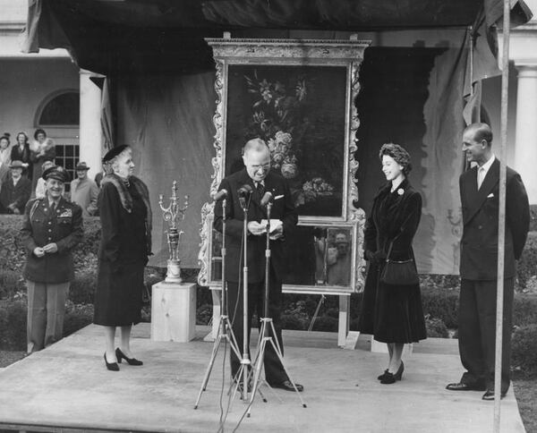 Princess Elizabeth and Prince Philip, the Duke of Edinburgh, smiling as President Harry Truman gives a speech and his aide, General Harry Vaughan (extreme left) looks on, in Washington DC, November 5th 1951.