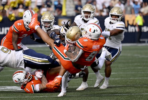 Georgia Tech defensive back Omar Daniels (21) brings down Miami tight end Elijah Arroyo (8) during the second half of an NCAA college football game at Georgia Tech's Bobby Dodd Stadium, Saturday, November 9, 2024, in Atlanta. Georgia Tech won 28-23 over Miami. (Hyosub Shin / AJC)