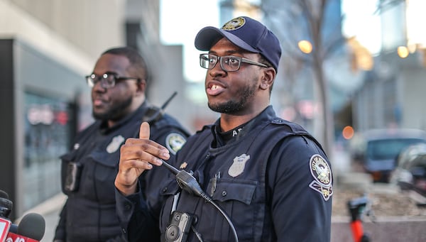 Atlanta police officers Marcus Todd (left) and Willie Adams IV (right) describe a daring rescue of a man pinned inside a burning vehicle Sunday morning in northwest Atlanta.