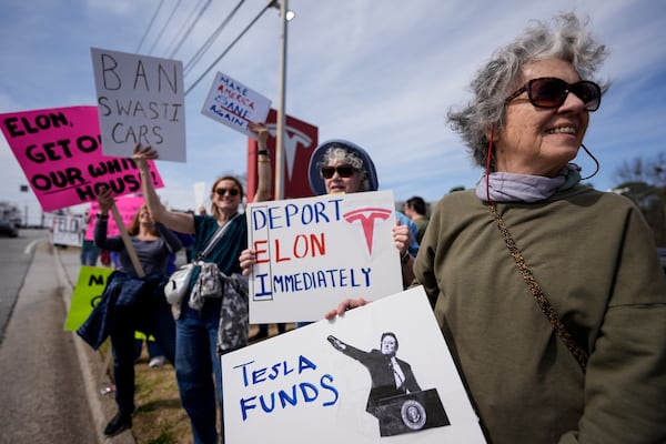 Marsha Partin, right, stands with other demonstrators during a protest of automaker billionaire CEO, Elon Musk near a Tesla vehicle dealership, Saturday, March 8, 2025, in Decatur, Ga. (AP Photo/Mike Stewart)