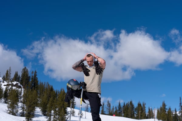 Ukrainian veteran Stanislav Povkhan adjusts his head covering as he pauses after going down a slope during a lesson with Oregon Adaptive Sports on the three track skiing method at Hoodoo Ski Area in central Oregon on Thursday, March 6, 2025. (AP Photo/Jenny Kane)