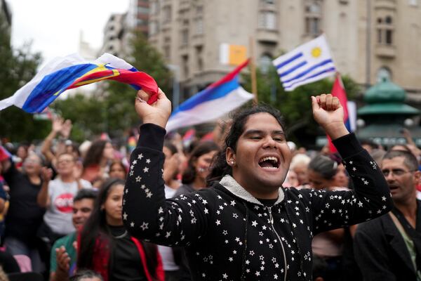 People gather with Uruguay's flags prior to President-elect Yamandu Orsi's swearing-in ceremony, on Inauguration Day in Montevideo, Uruguay, Saturday, March 1, 2025. (AP Photo/Matilde Campodonico)