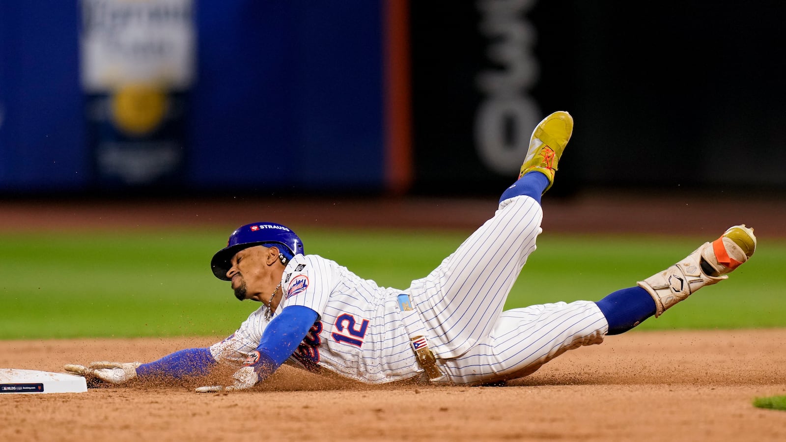 New York Mets shortstop Francisco Lindor (12) slides safely into second base for a two-run RBI double against the Philadelphia Phillies during the eighth inning of Game 3 of the National League baseball playoff series, Tuesday, Oct. 8, 2024, in New York. (AP Photo/Seth Wenig)