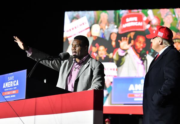 Herschel Walker, front-runner for the party’s U.S. Senate nominee, speaks as former President Donald Trump looks on during a rally for Georgia GOP candidates at Banks County Dragway in Commerce on Saturday, March 26, 2022. Trump warns that Walker's campaign could be hurt if Gov. Brian Kemp becomes the GOP's choice to face Democrat Stacey Abrams again. (Hyosub Shin / Hyosub.Shin@ajc.com)