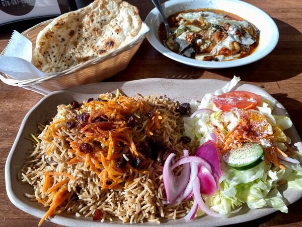 Olomi’s Grill in Johns Creek serves an impeccable version of the crown jewel of Afghani cuisine: Kabuli pulao (lamb pilaf), shown here with Iranian-style barbari flatbread and borani bandjan (eggplant and potatoes). 
Wendell Brock for The Atlanta Journal-Constitution