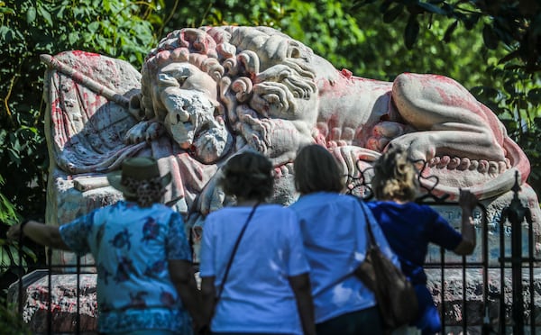 Cemetery visitors look at the results of the attempted cleaning of the statue at Oakland Cemetery in 2020. JOHN SPINK/JSPINK@AJC.COM