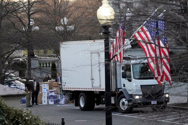 FILE - A van arrives to pick up boxes that were moved out of the Eisenhower Executive Office building, inside the White House complex, Jan. 14, 2021, in Washington. (AP Photo/Gerald Herbert, File)