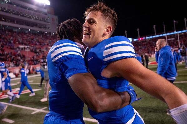 BYU quarterback Jake Retzlaff, right, and cornerback Mory Bamba celebrate after a one-point win over Utah in an NCAA college football game, just after midnight on Sunday, Nov. 10, 2024, in Salt Lake City. (AP Photo/Spenser Heaps)