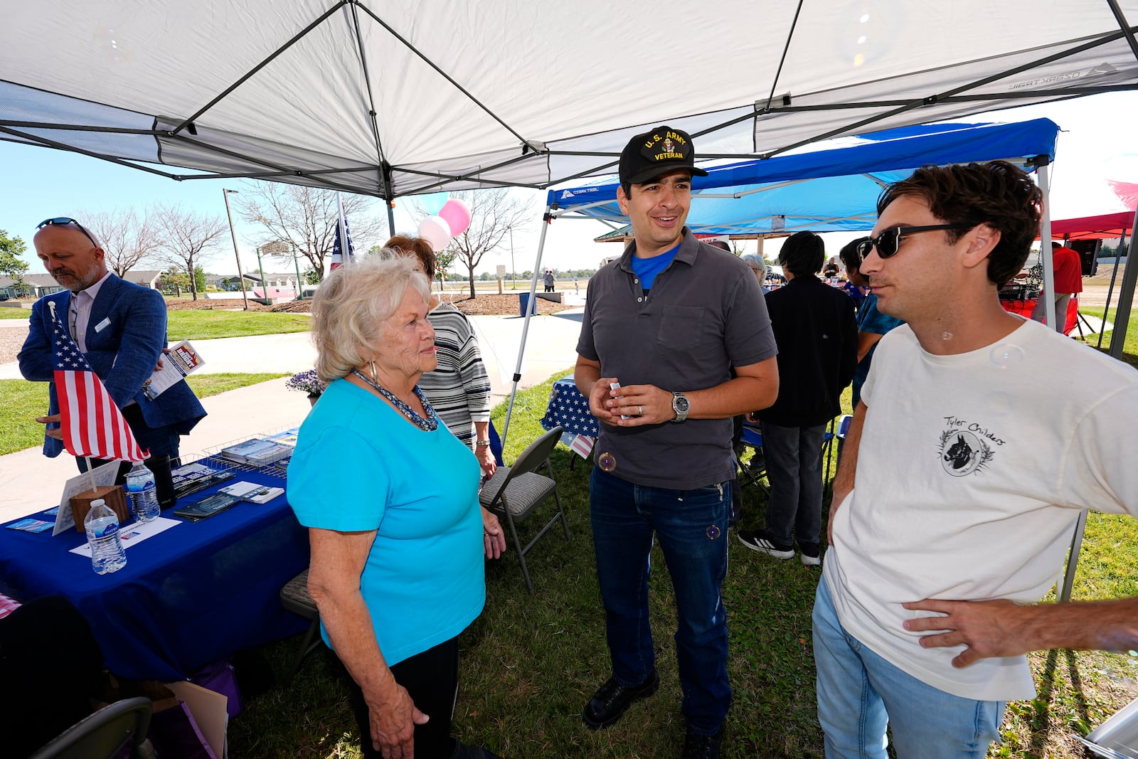 Gabe Evans, Republican candidate for the U.S. House District 8 in Colorado, talks to Annette Hayes during a campaign stop Saturday, Sept. 28, 2024, in Evans, Colo. (AP Photo/David Zalubowski)