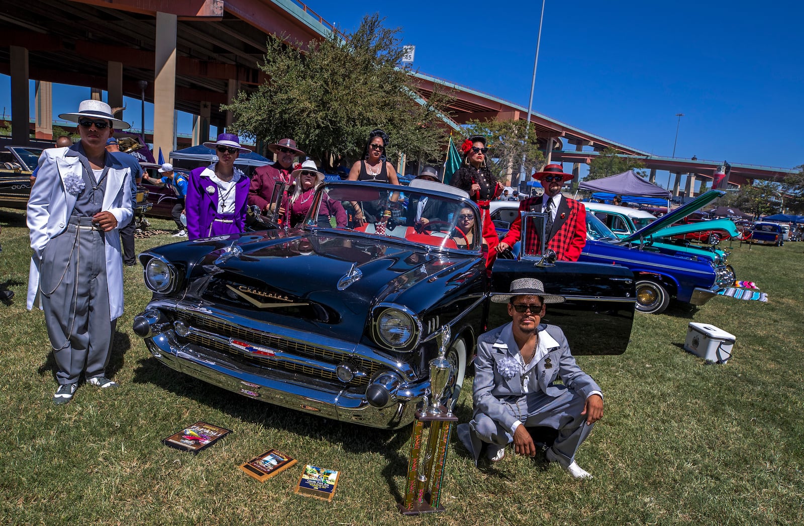 Attendees of a lowrider exhibition, wearing Zoot suits of the Mexican American subculture known as Pachucos, pose for a photo on a vintage car during the 20th anniversary of Lincoln Park in El Paso, Texas, Sunday, Sept. 22, 2024. (AP Photo/Andrés Leighton)