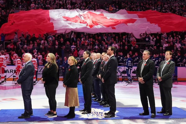 2024 Hockey Hall of Fame inductees Colin Campbell, left to right, Krissy Wendell-Pohl, Natalie Darwitz, Pavel Datsyuk, Shea Weber, Jeremy Roenick and David Poile stand for the national anthems following a pre-game ceremony prior to NHL hockey action between the Detroit Red Wings and Toronto Maple Leafs in Toronto on Friday, November 8, 2024. (Frank Gunn/The Canadian Press via AP)