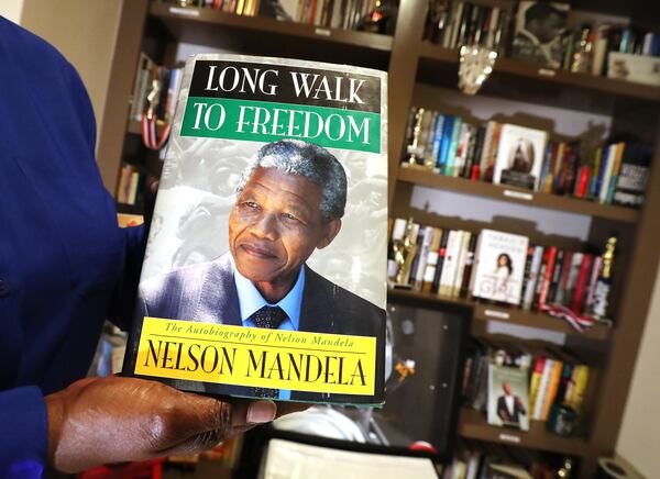 Theresa Easton shows off one of the hundreds of first edition autographed books she calls her “pride and joy” in the library of her home. Curtis Compton/ccompton@ajc.com