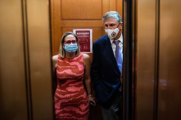 U.S. Sen. Kyrsten Sinema, D-Ariz., and U.S. Sen. Joe Manchin, D-W.Va., catch an elevator to go to the Senate Chamber in the U.S. Capitol on Thursday, Sept. 30, 2021, in Washington, D.C. (Kent Nishimura/Los Angeles Times/TNS)