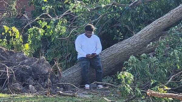 A Paine College students sits on a fallen tree on the Augusta campus. The private institution suffered serious damage from Hurricane Helene. (Courtesy of Paine College)